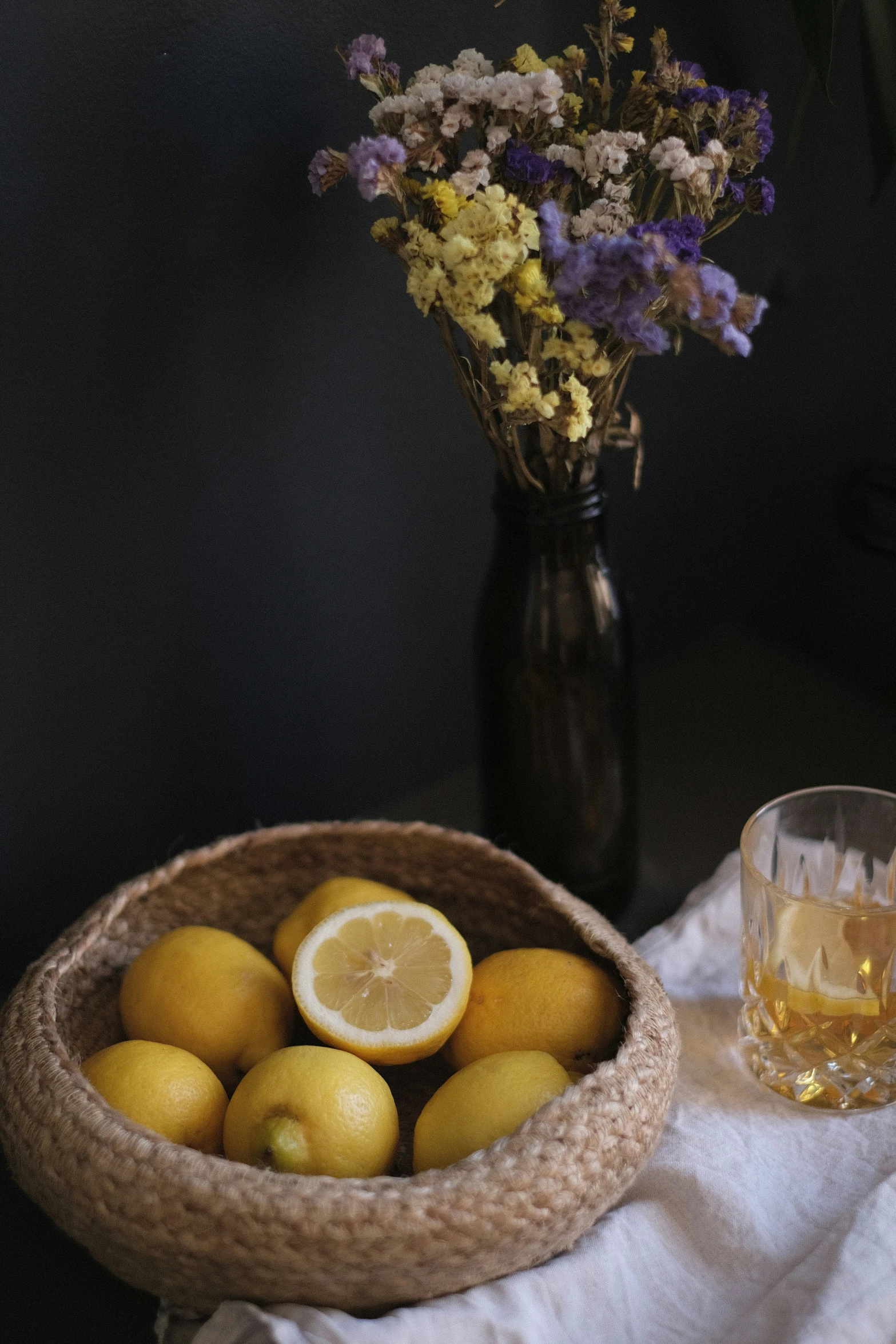 a basket full of lemons with some glasses