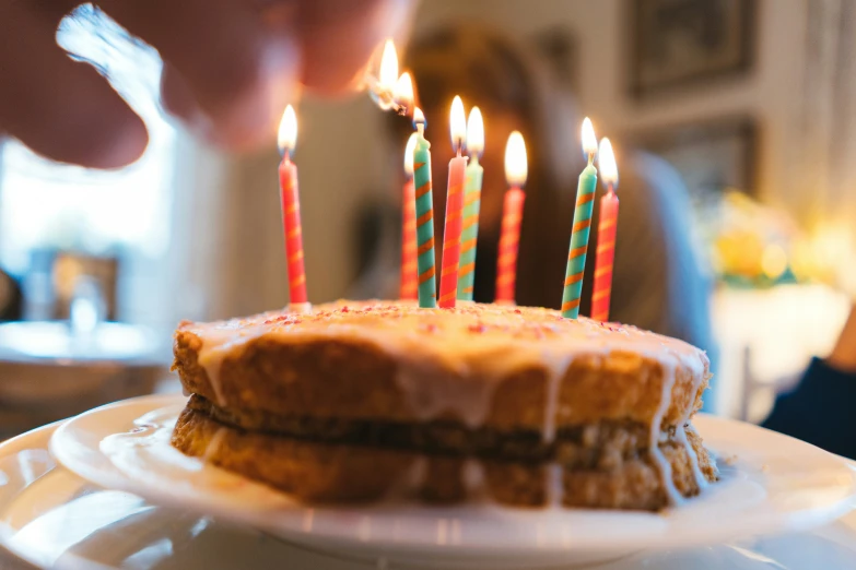 a cake with candles is lit on the dining table