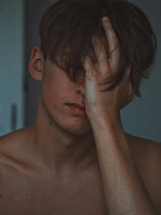 a man holding his hands to his head in a shirtless manner