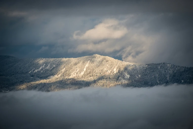 mountains are covered in low cloud and snow