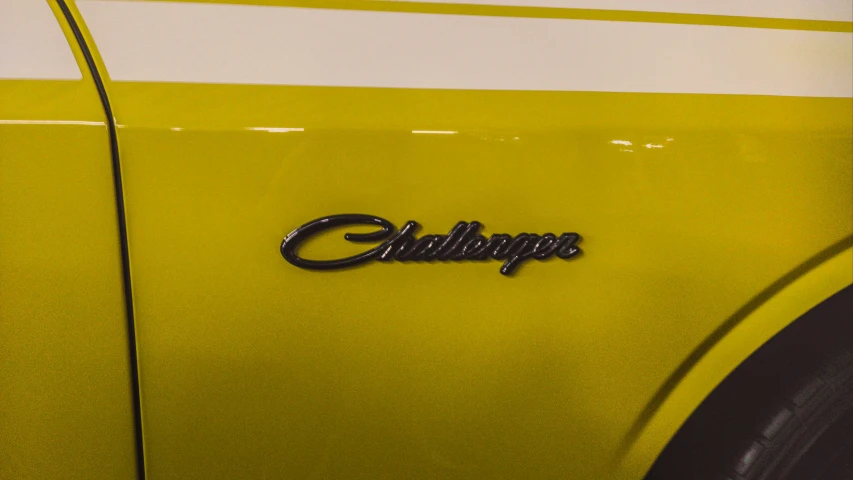 a close up of the emblem on an old style yellow car