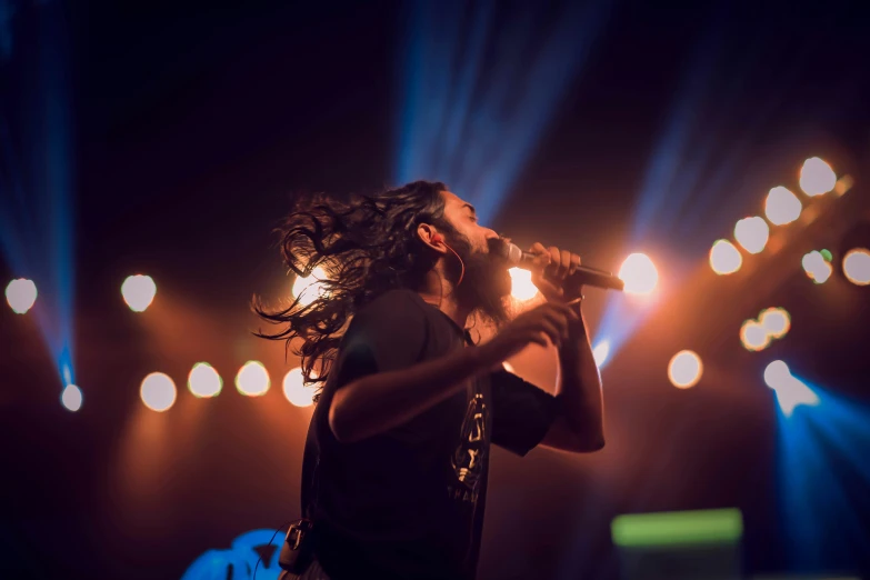 a man with dreadlocks is singing into some microphones