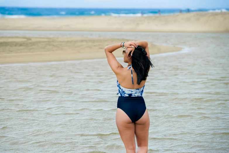 girl standing in water and looking out into beach