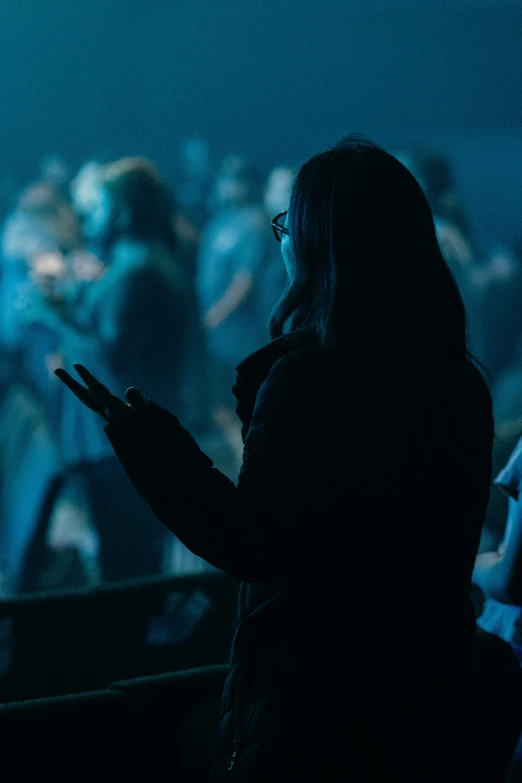 a person wearing glasses looking out over an audience