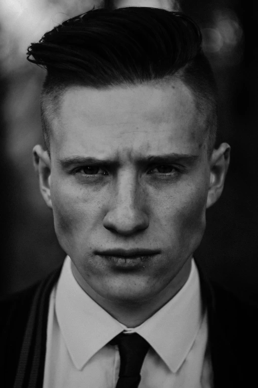 black and white pograph of man with messy hair in tie