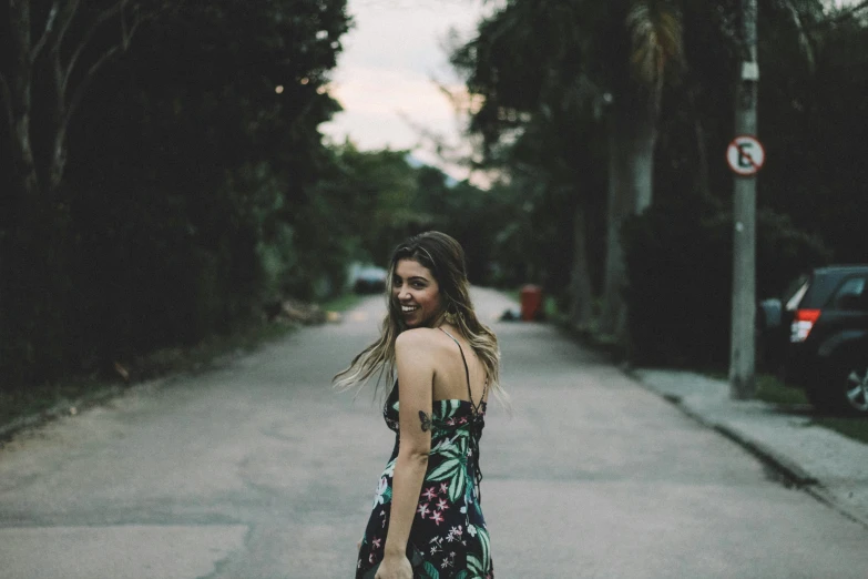 a woman walking down the street holding a skateboard