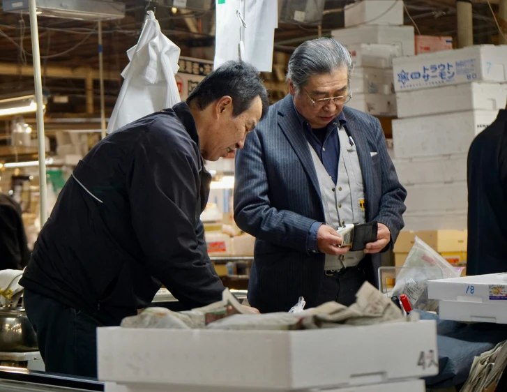 two men looking at boxes in a warehouse