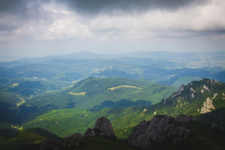 the view from the top of the mountain shows a valley, mountains, and forests