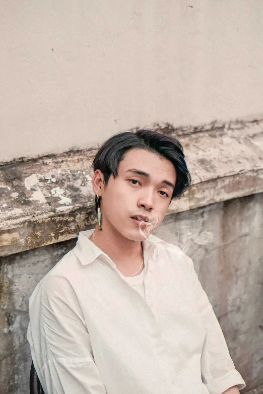 a boy with cigarette in his mouth is sitting on a chair