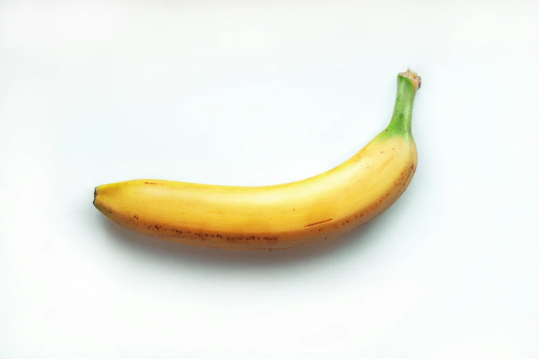 a banana is laying on a white surface