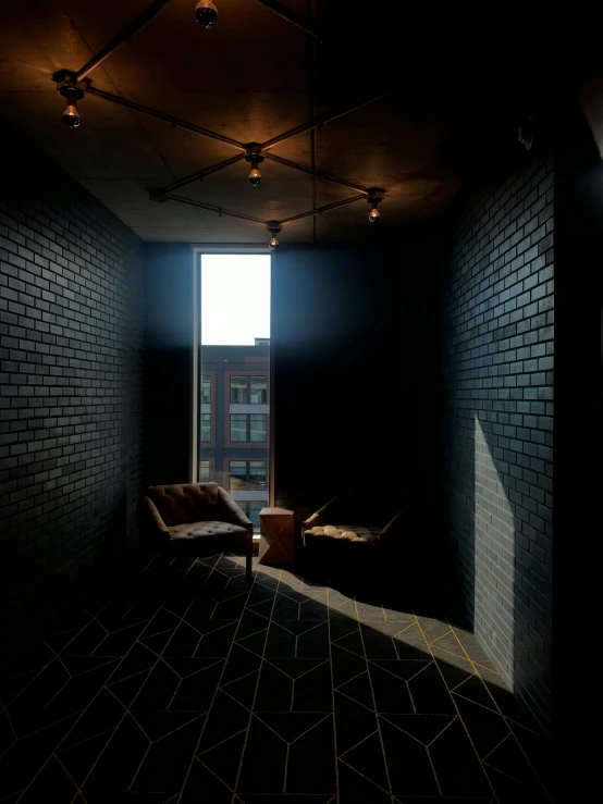 a dimly lit room has a leather chair near an open window