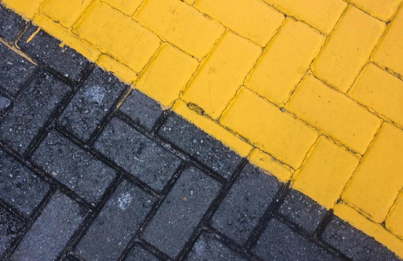 a cross walk painted yellow and grey and grey tiles