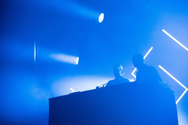 a dj playing a sound board on stage at a concert