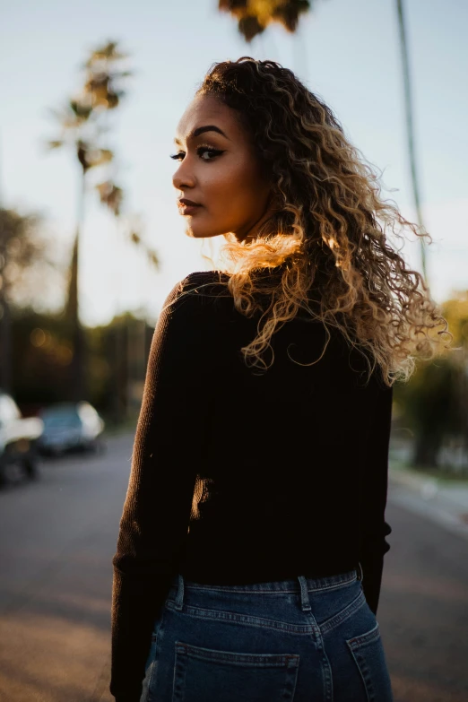 a woman with curly hair wearing a black sweater