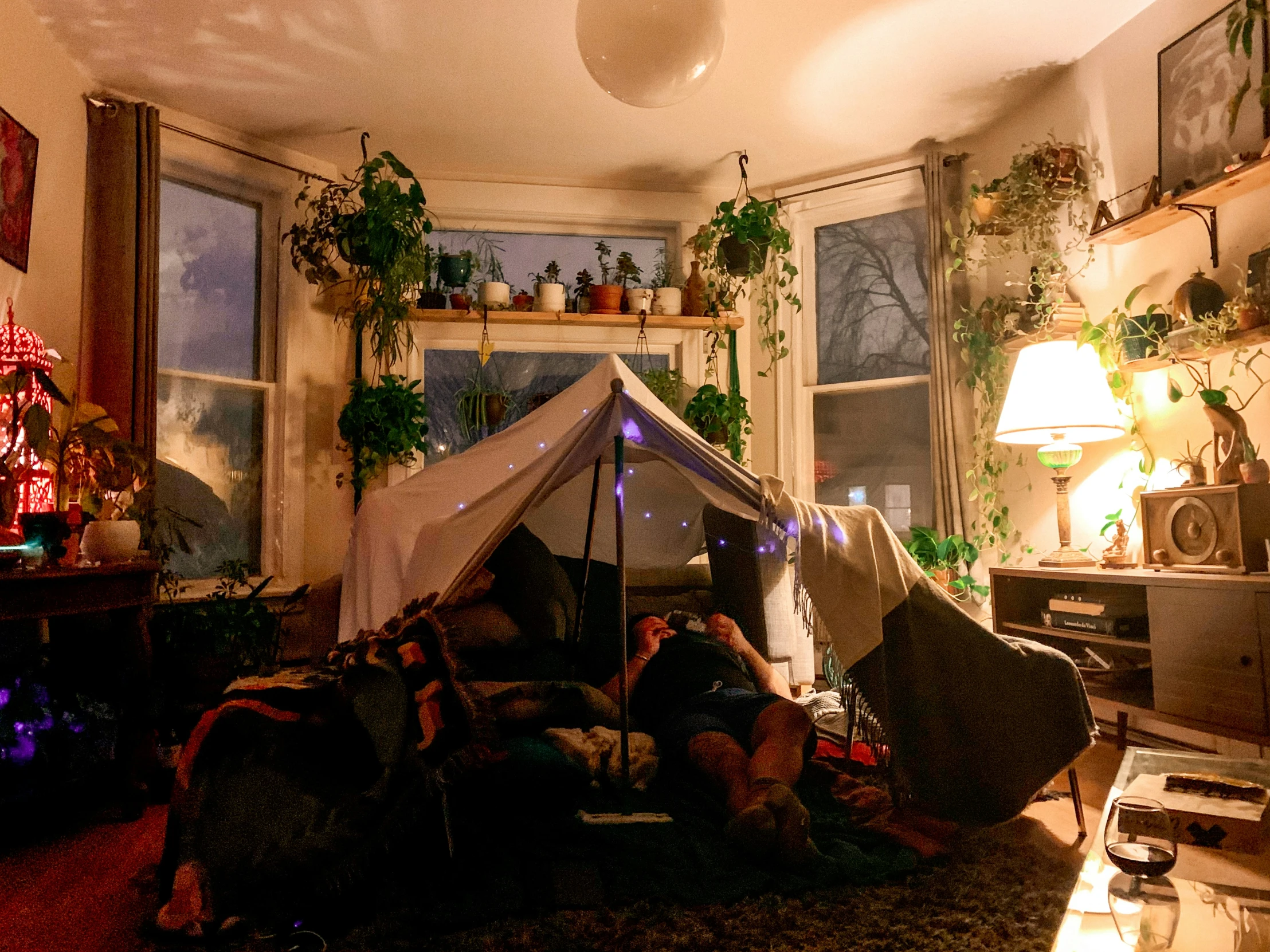 the girl is inside of the tent in her living room