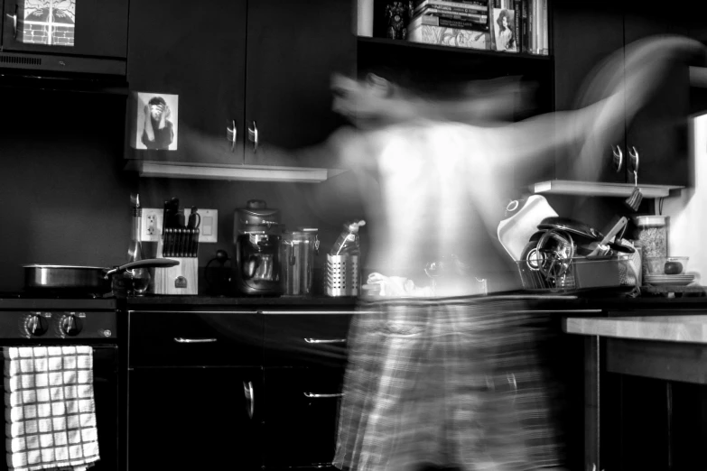 the blurry image shows a woman in the kitchen