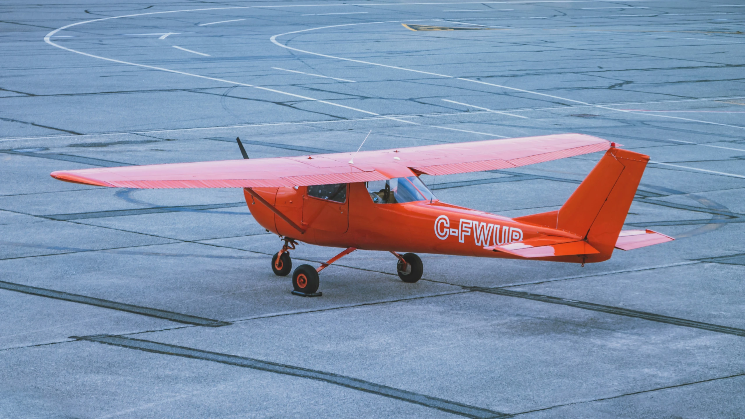 a small airplane sits on the ground near a pavement