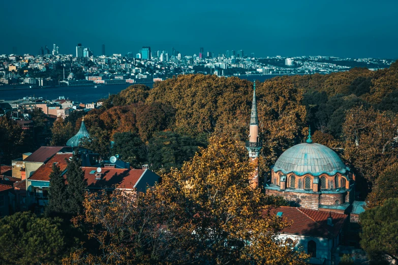 a cityscape with a church tower surrounded by fall foliage