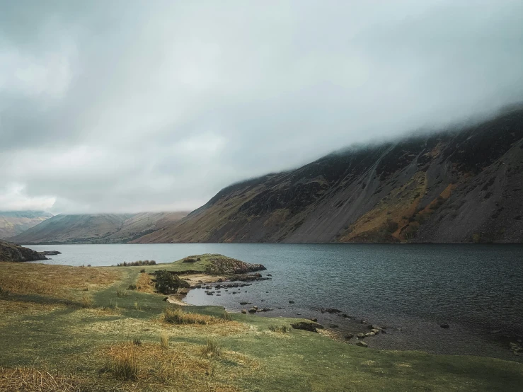 clouds are seen over a mountain lake on a stormy day