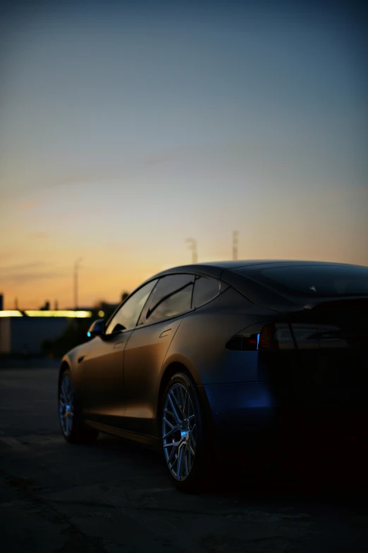 a silver car parked at dusk near the water