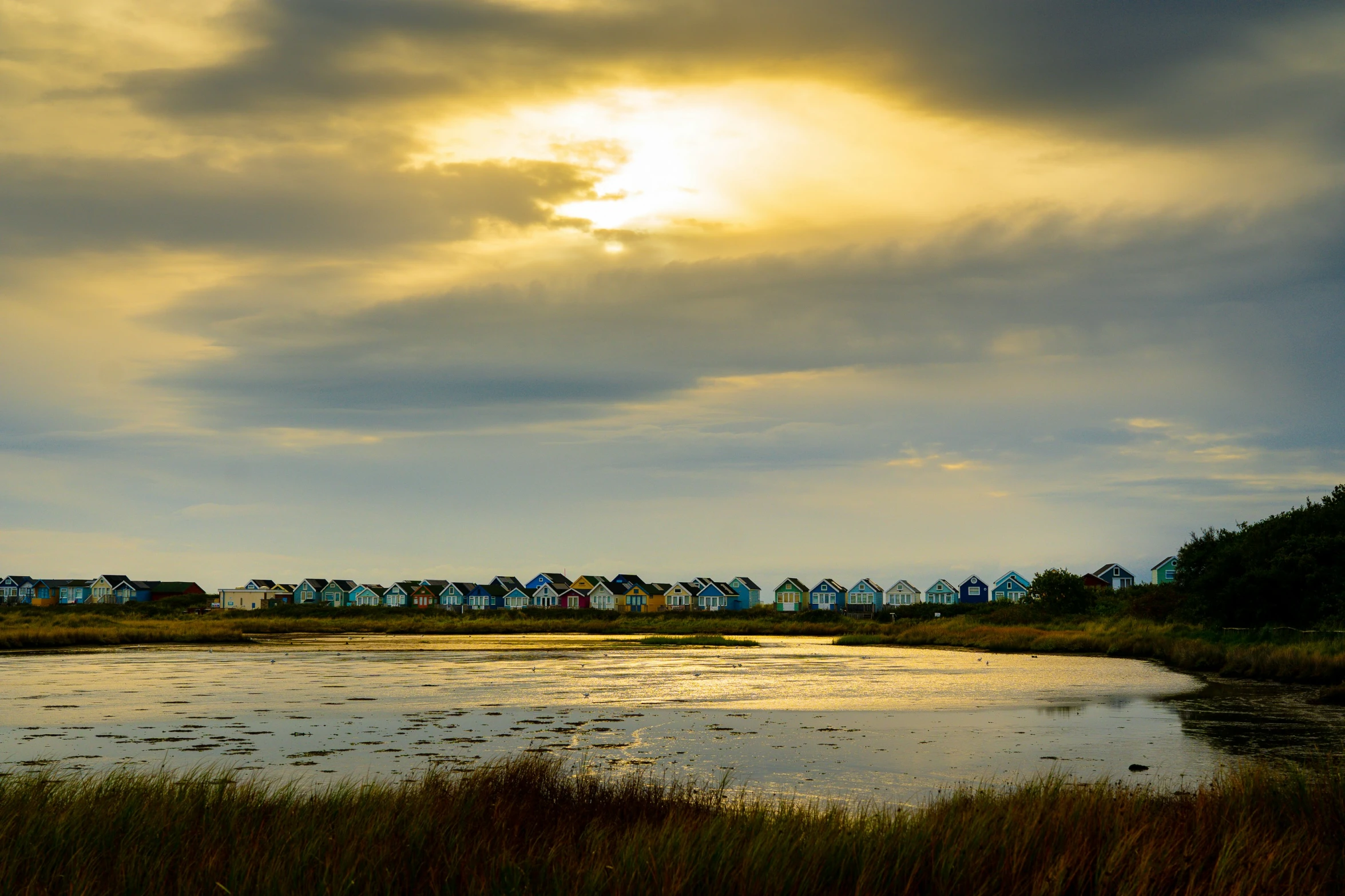 some houses by a body of water and clouds