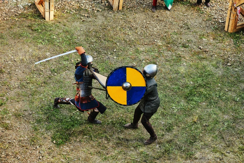 a man standing next to another man with a sword and shield