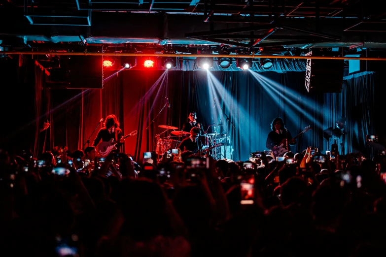 a band performing on stage at night with spotlights