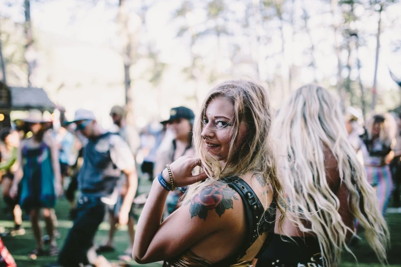 a woman with tattoos standing in the grass