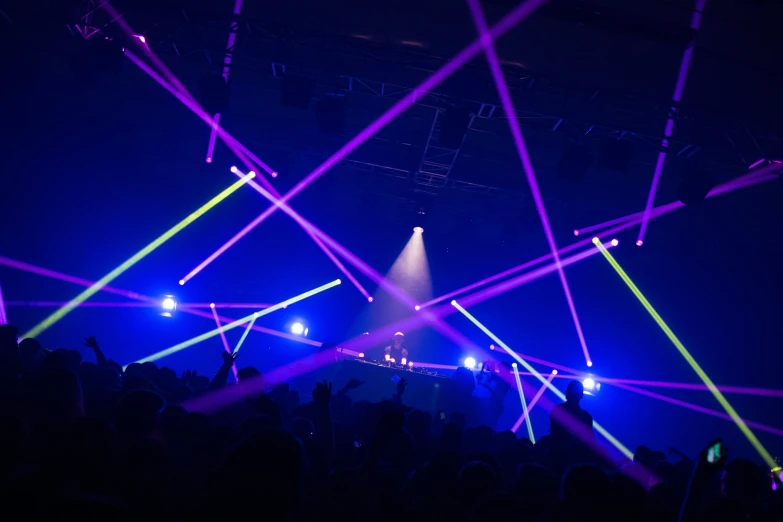 a crowd on a stage with several colorful lights