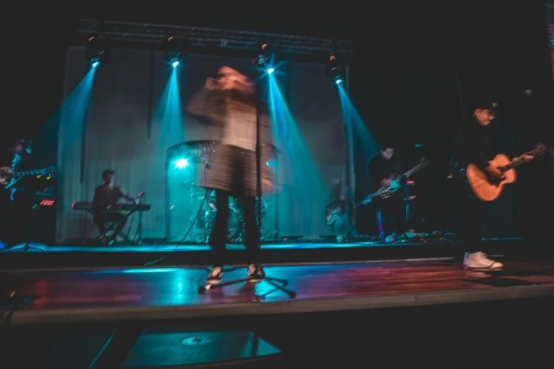 some music band members singing and playing on stage