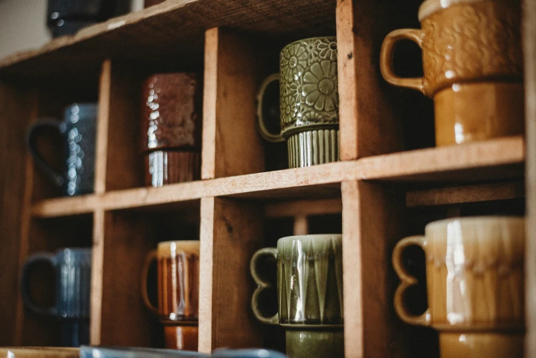 many cups lined up in wooden shelving and stacked