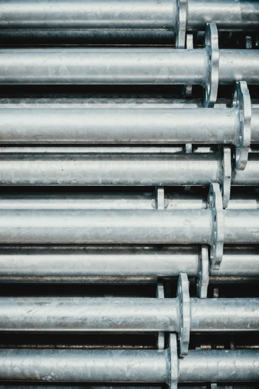 many metal pipes are stacked up together