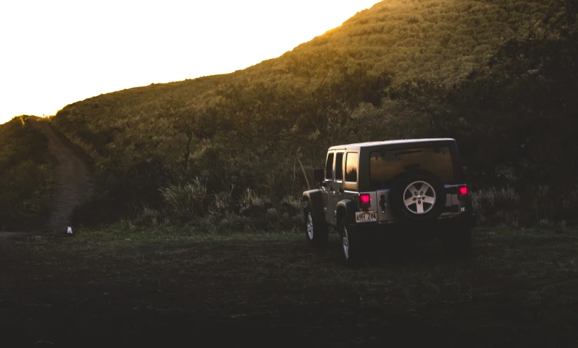 a black jeep sits in the shadow of mountains