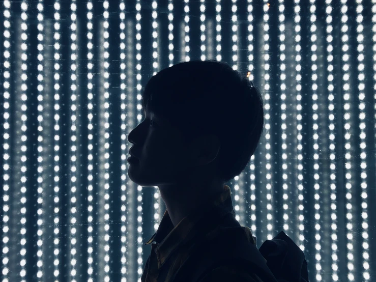 a man standing in front of a wall of lights