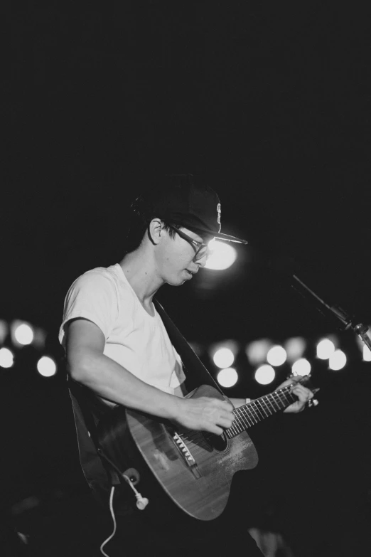 a man is playing an acoustic guitar in the dark