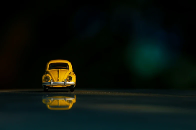 a small yellow car with its head light on