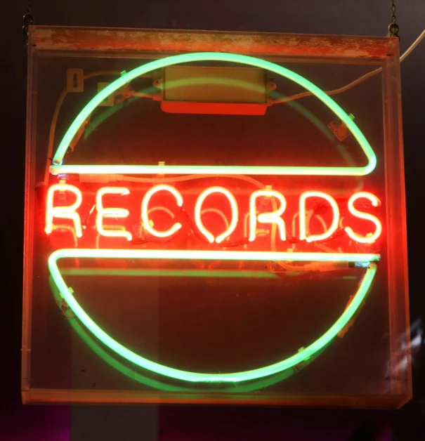 a neon sign on the side of a building that reads records