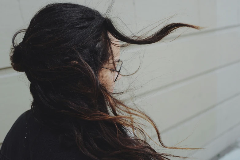 woman with long dark hair blowing her wind blown up