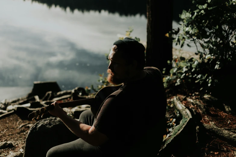 a person that is sitting down playing a guitar