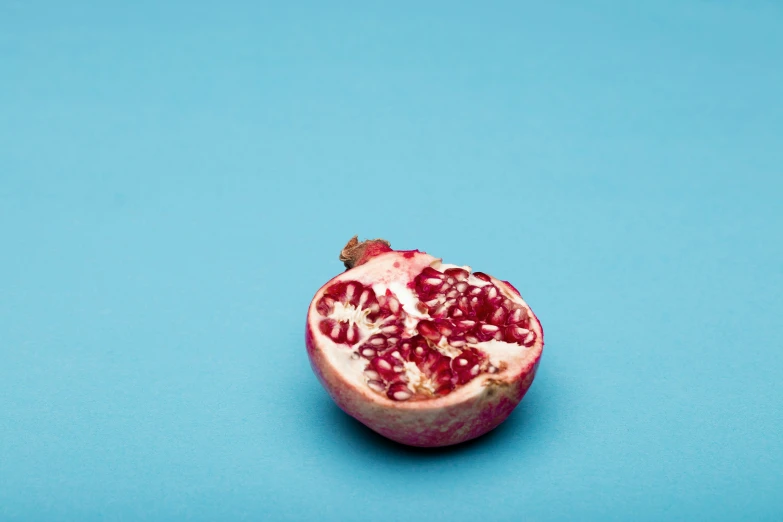 the open pomegranate is shown on a blue background