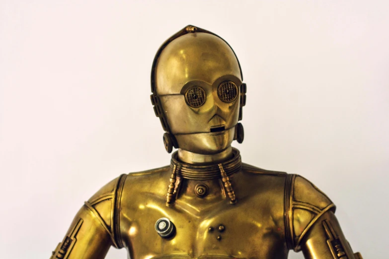 the figurine shows a man as a robot in a gold costume