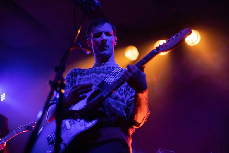 a man that is standing up with a guitar