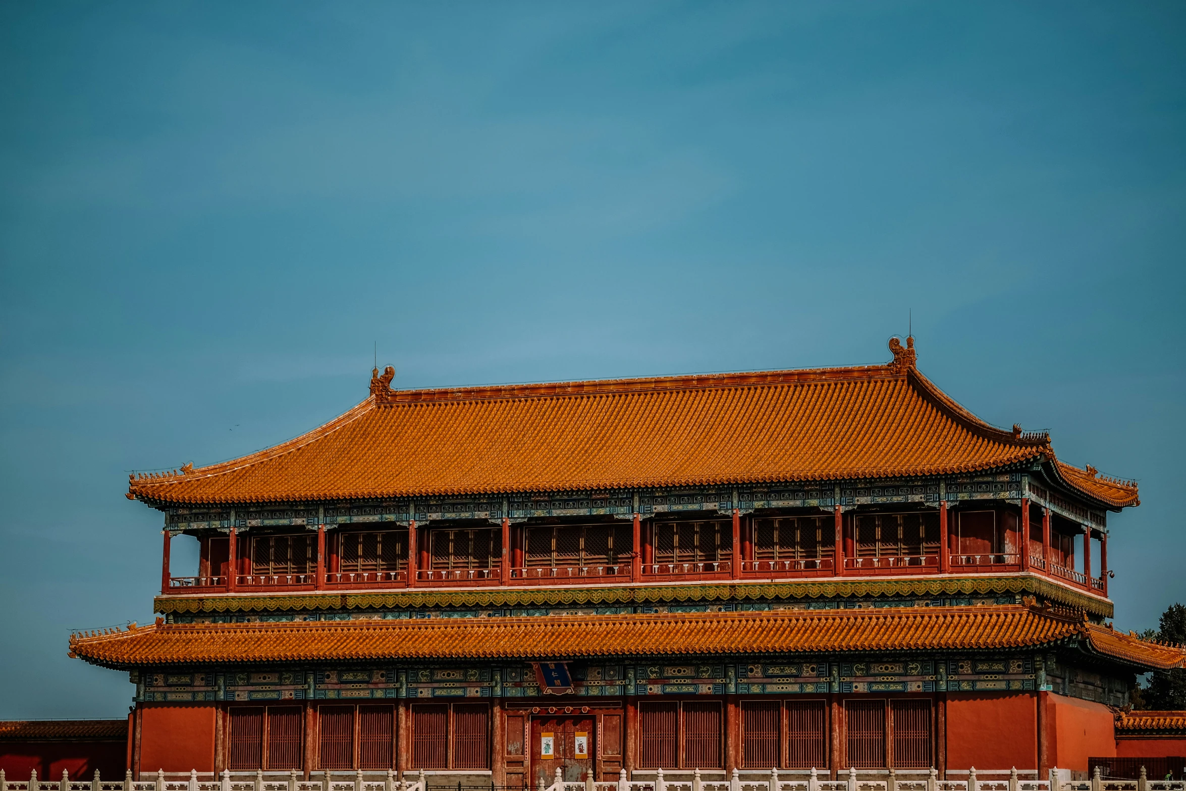 a tall, old building with orange tiles and red pillars