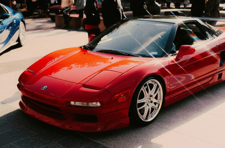 a red sports car parked in front of people