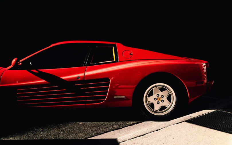 a red ferrari parked next to a curb