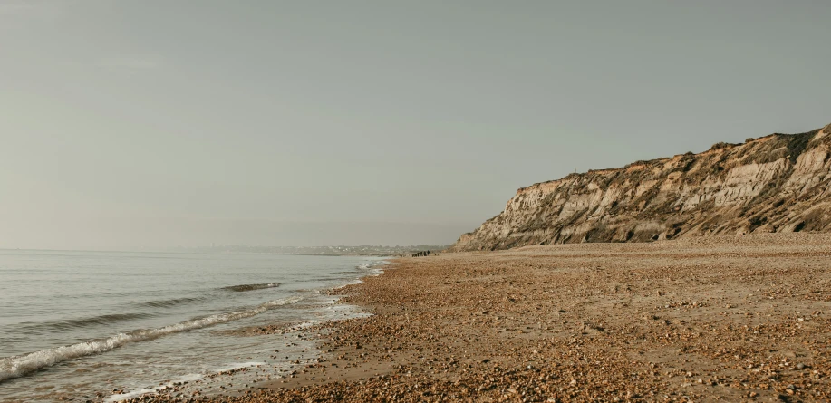 a rocky, sandy shore line is seen from the ocean