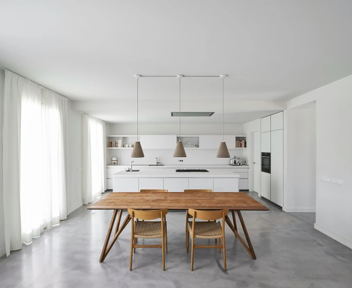 a dining table sits between two stools in the middle of the room