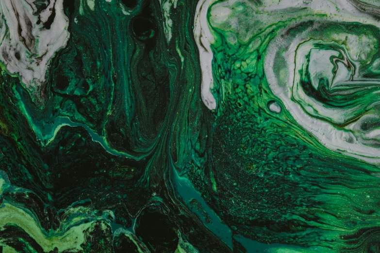 a close up of a liquid paint swirls in green