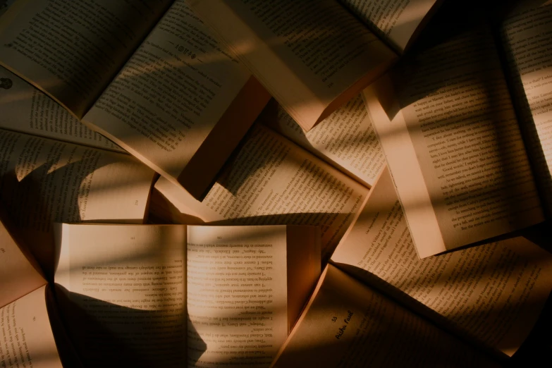 a pile of opened book sitting on top of a floor