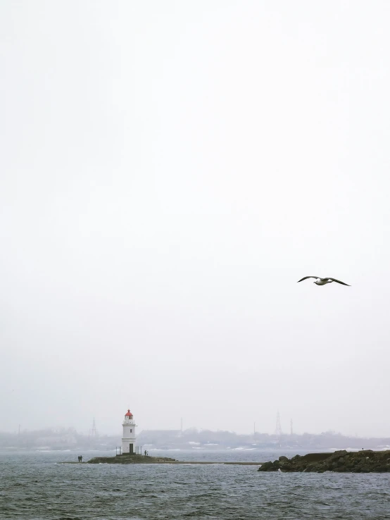 a lighthouse on a beach in the fog